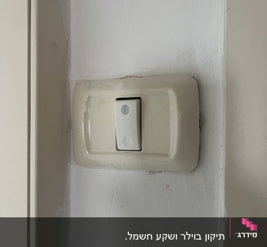 מתג חשמל לבן על קיר לבן